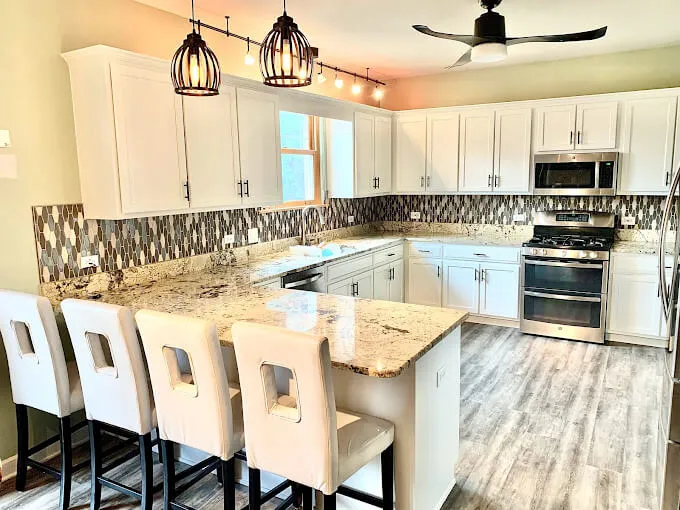 White painted kitchen cabinets with granite counters and bar seating in the Chicago suburbs
