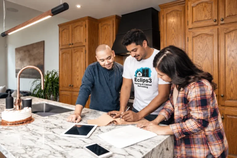 Eclips3 cabinet specialist reviewing refacing options with a couple at their kitchen island