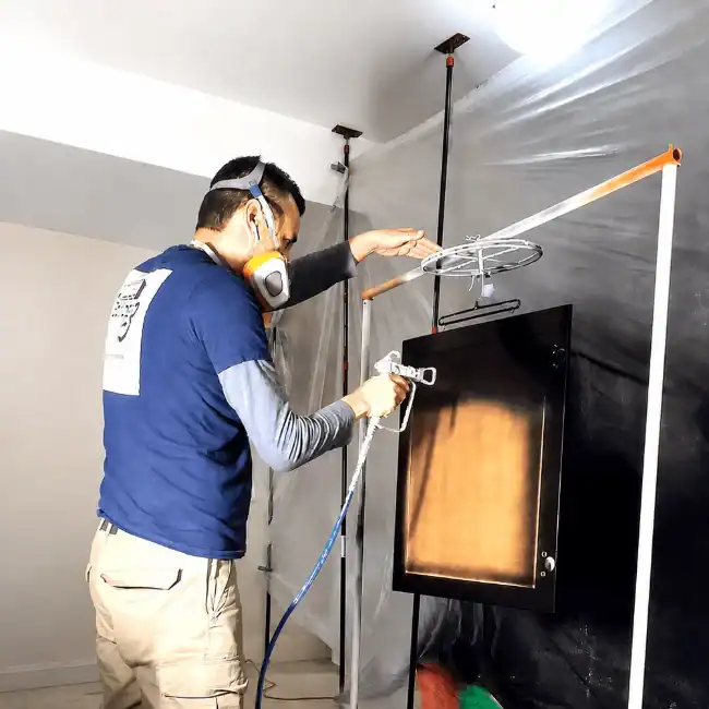 Eclips3 painter spraying kitchen cabinet doors in the shop
