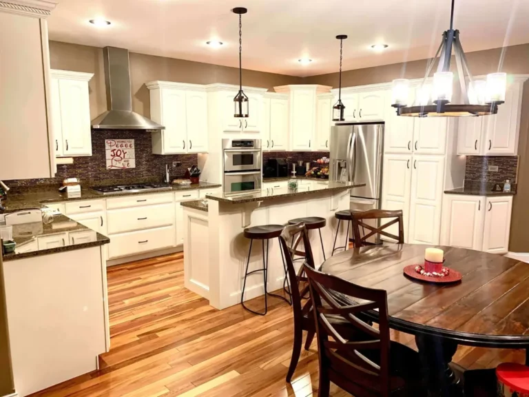 White kitchen cabinets refinished by Eclips3 with a dark tile backsplash and island seating in the Chicago suburbs