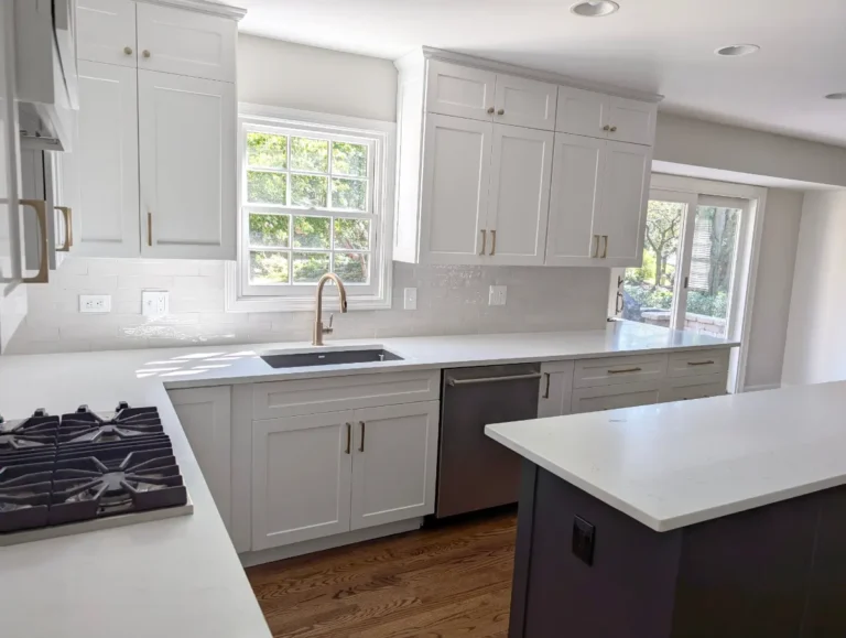 White kitchen sink wall with a window, brass faucet and charcoal island