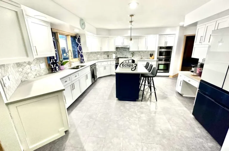 Wide kitchen view with white shaker cabinets, a navy center island, pale counters and patterned backsplash