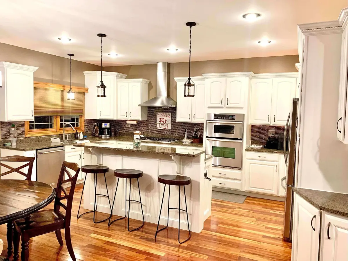Cabinet painting: white painted kitchen cabinets and island with bar stools
